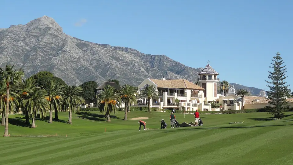 Campo de golf con palmeras y la sierra al fondo