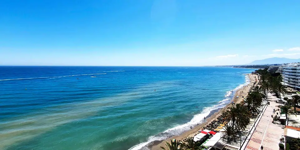 Playa y paseo marítimo de Marbella vistos desde lo alto, con el Mediterráneo en calma